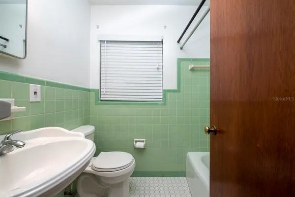 a bathroom with a sink a toilet and mirror