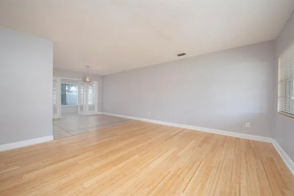 a view of empty room with wooden floor