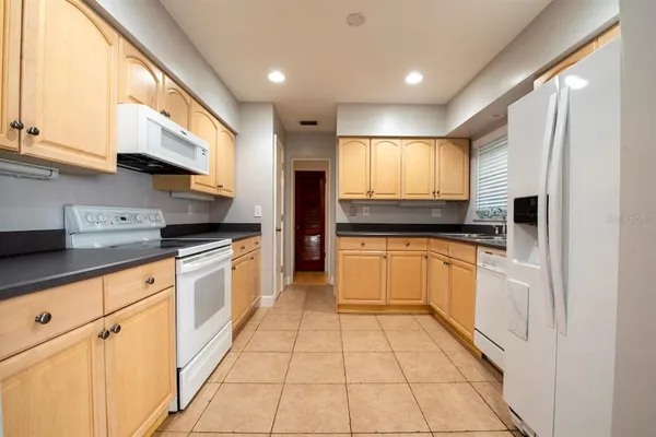 a kitchen with stainless steel appliances granite countertop a refrigerator and a sink