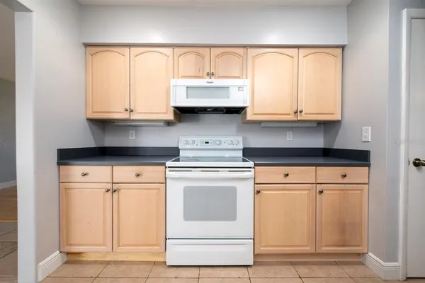 a kitchen with granite countertop white cabinets and white appliances