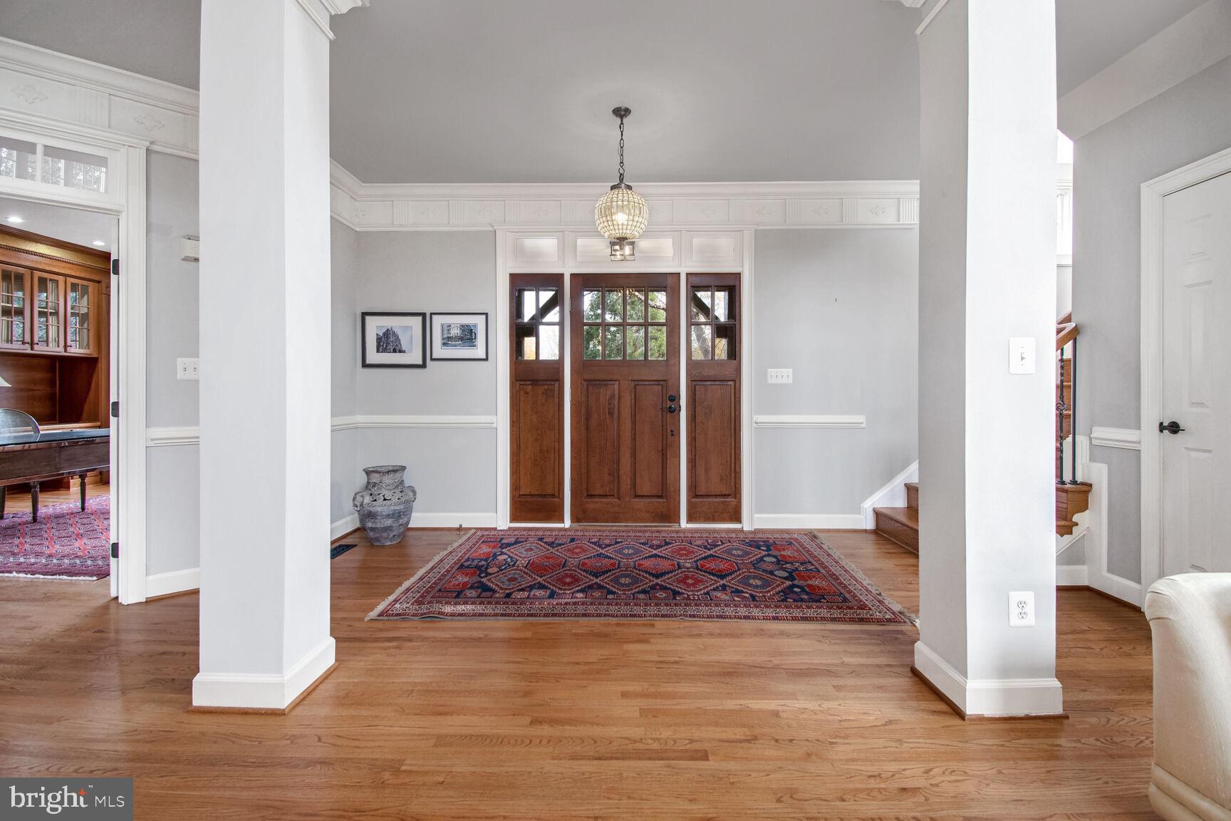 1550 Shelford Court Vienna, VA 22182 - Photo 11 of 60 a view of a hallway with wooden floor and a chandelier