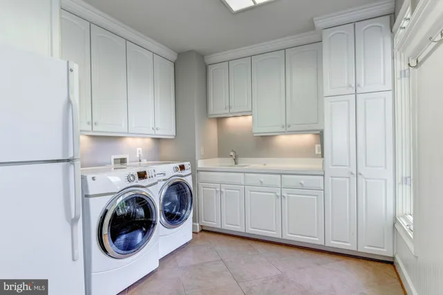 a utility room with sink dryer and washer
