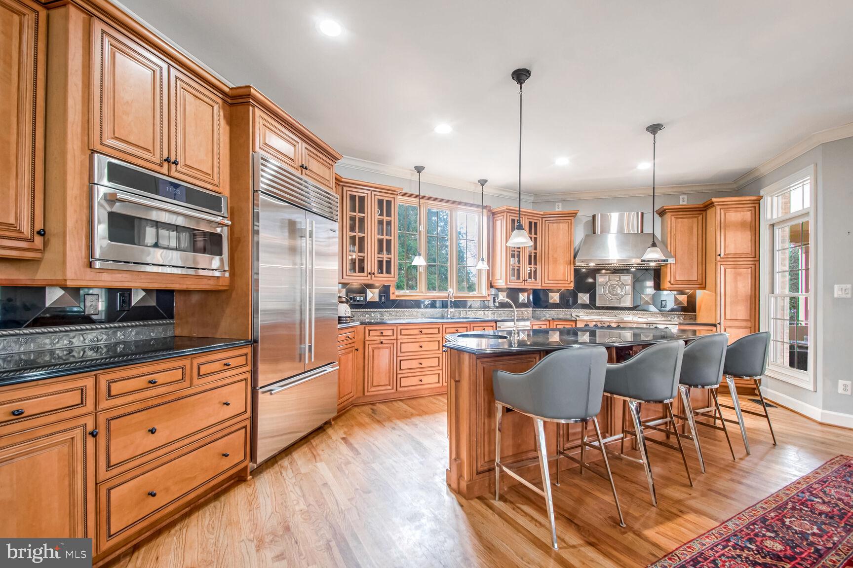 1550 Shelford Court Vienna, VA 22182 - Photo 26 of 60 a kitchen with stainless steel appliances granite countertop wooden floors and white cabinets