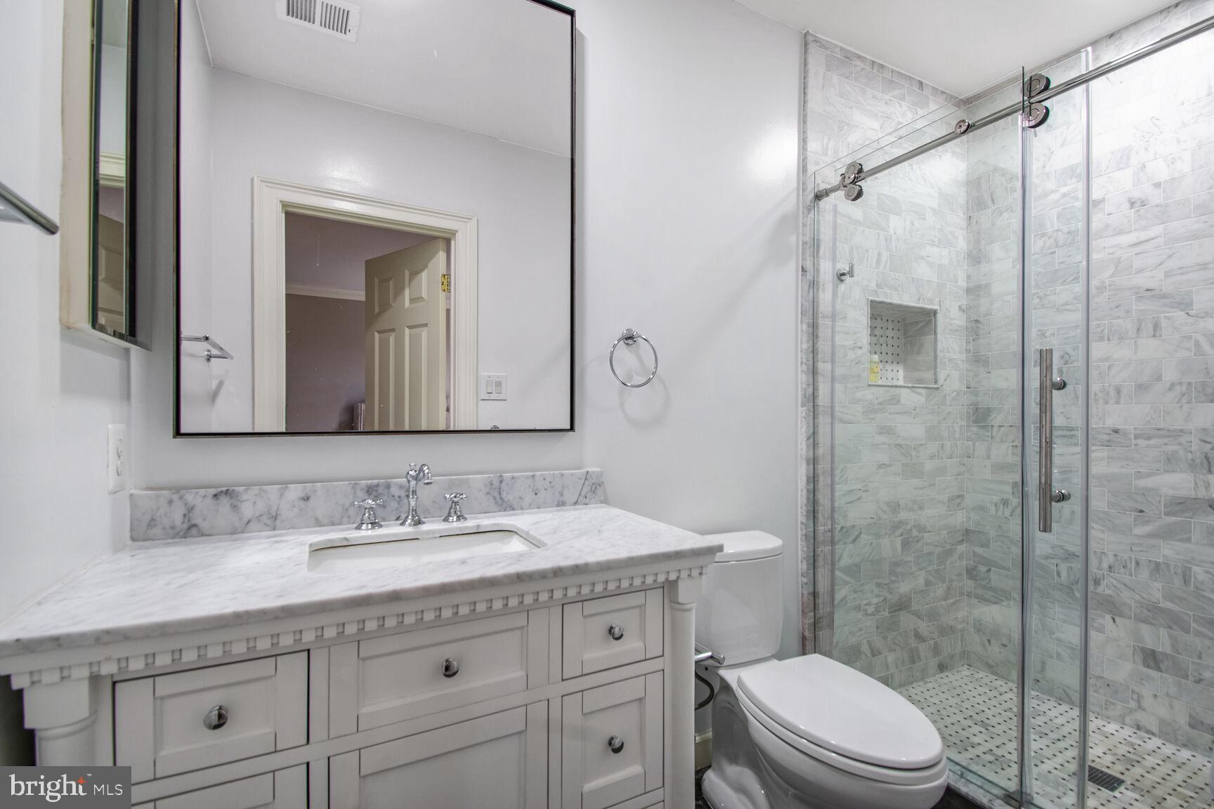 1550 Shelford Court Vienna, VA 22182 - Photo 53 of 60 a bathroom with a granite countertop sink a toilet and a mirror