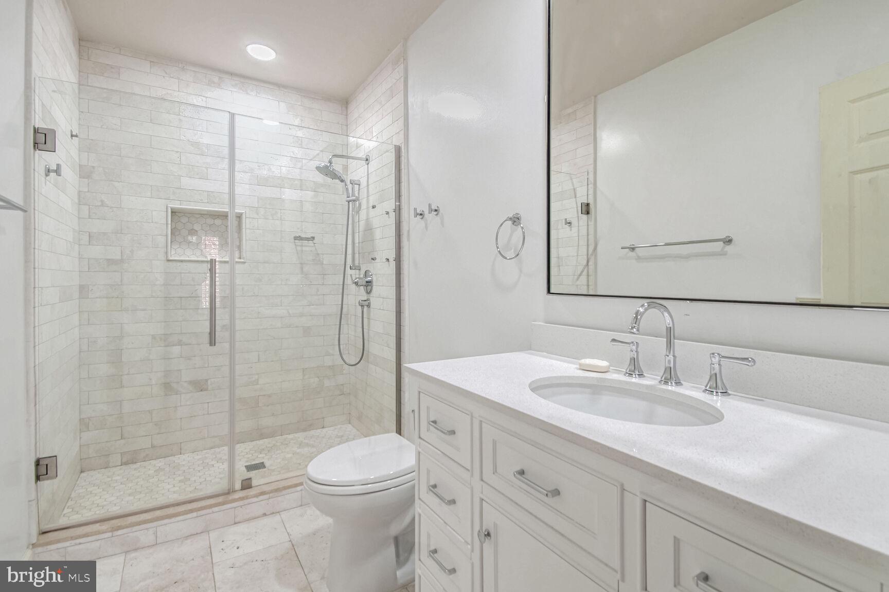 1550 Shelford Court Vienna, VA 22182 - Photo 54 of 60 a bathroom with a shower sink vanity mirror and toilet