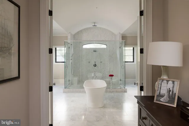 a white bath tub sitting in a bathroom and a shower