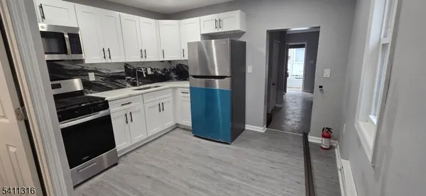 a kitchen with stainless steel appliances granite countertop a refrigerator and a stove top oven