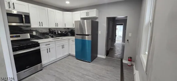 a kitchen with stainless steel appliances granite countertop a refrigerator stove and sink
