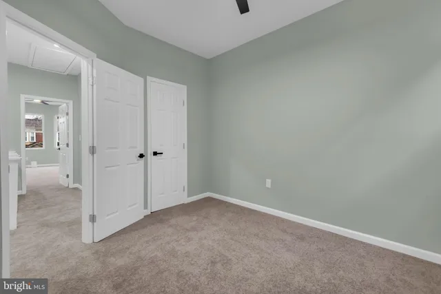 an empty room with windows and ceiling fan