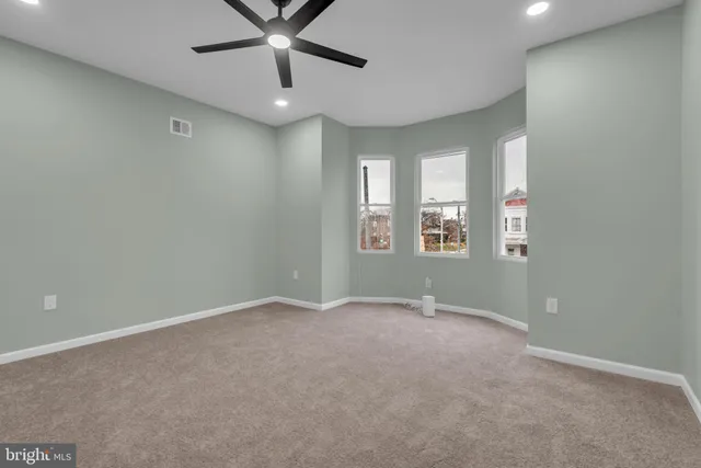 an empty room with closet and a ceiling fan