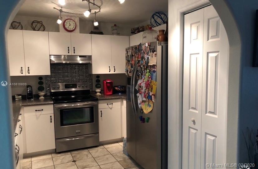 128 Kilpatrick Road Clewiston, FL 33440 - Photo 11 of 35 a kitchen with stainless steel appliances granite countertop a refrigerator and a stove top oven