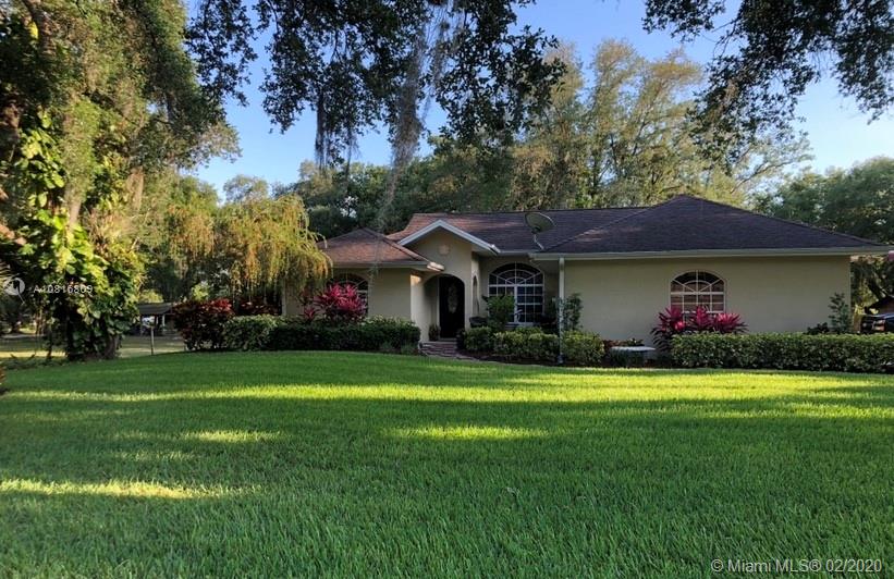 128 Kilpatrick Road Clewiston, FL 33440 - Photo 2 of 35 a front view of a house with a garden and trees