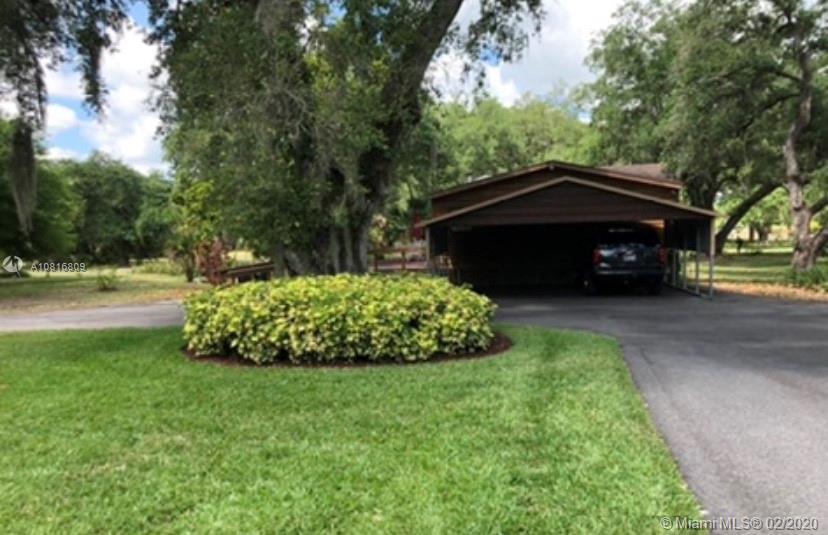 128 Kilpatrick Road Clewiston, FL 33440 - Photo 30 of 35 a view of a garden with a car parked