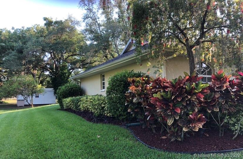 128 Kilpatrick Road Clewiston, FL 33440 - Photo 3 of 35 a view of a backyard with plants and a fountain