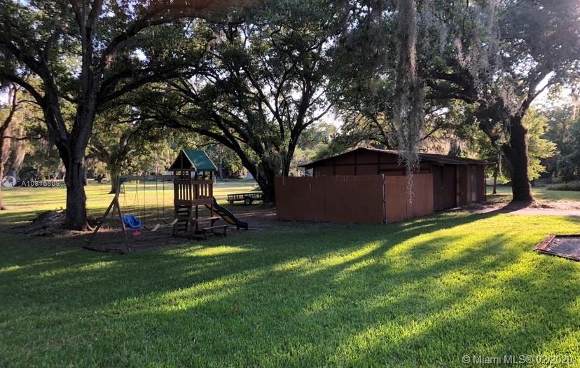 128 Kilpatrick Road Clewiston, FL 33440 - Photo 6 of 35 a view of a backyard with large trees