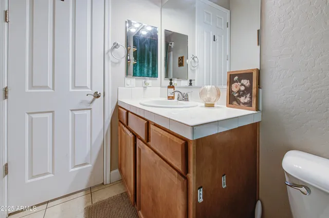 a bathroom with a sink a toilet and a mirror