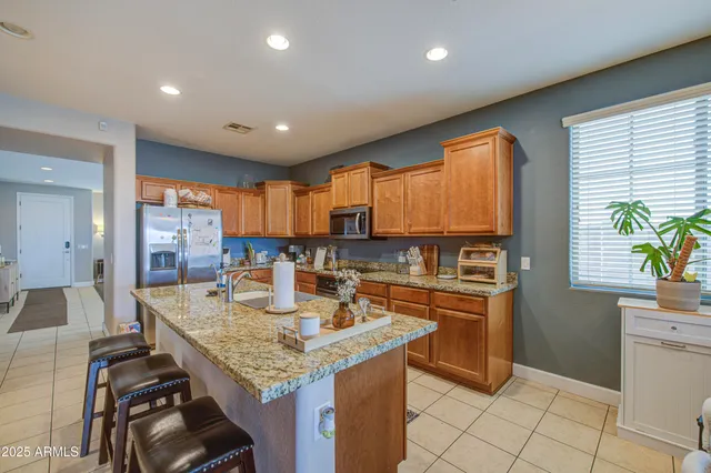 a kitchen with granite countertop kitchen island stainless steel appliances a sink stove and cabinets