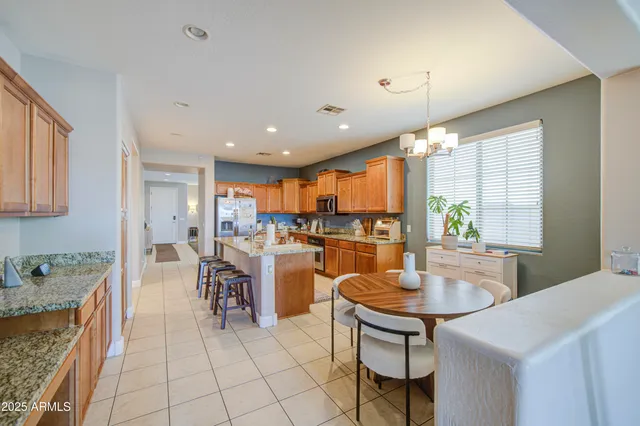 a kitchen with stainless steel appliances granite countertop table chairs sink and cabinets