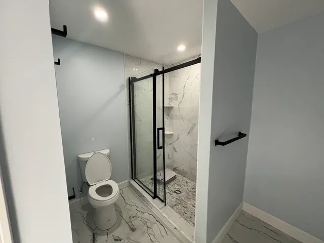 a bathroom with a toilet and a shower