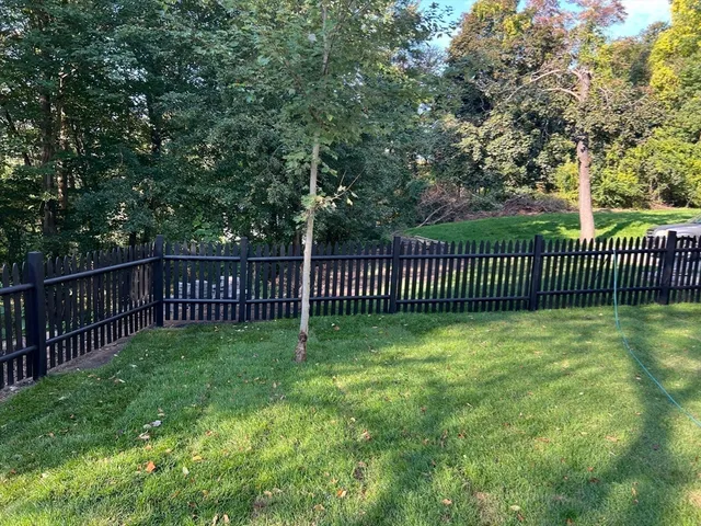 a view of a yard with wooden fence