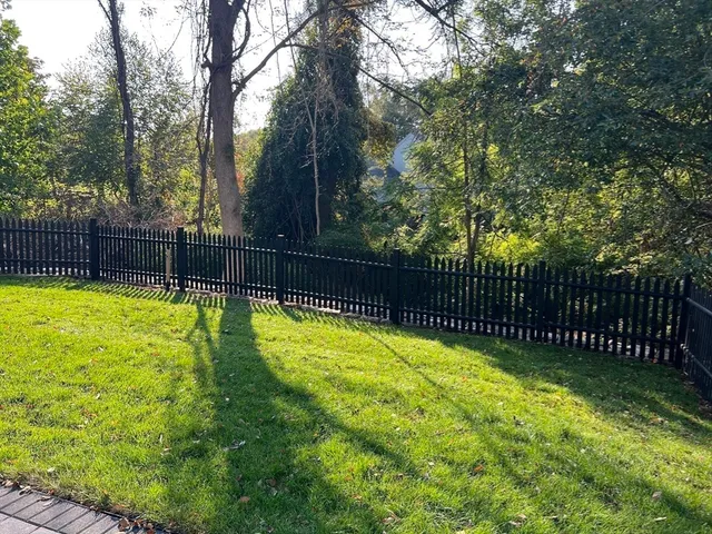 a view of yard with swimming pool and wooden fence