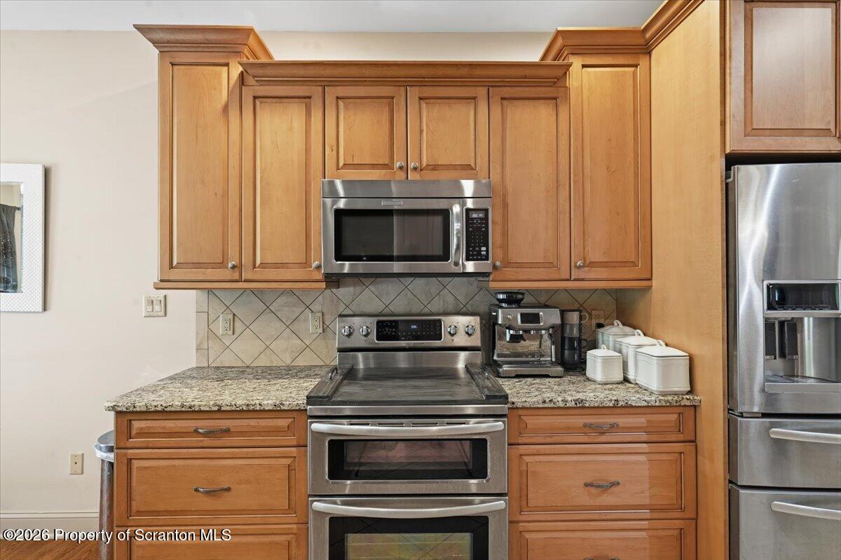 99 Hilltop Road Waverly, PA 18471 - Photo 16 of 41 a kitchen with granite countertop a stove and a microwave