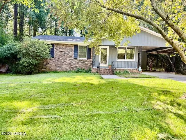a view of a house with a backyard and a tree