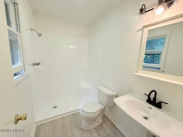 a bathroom with a sink a toilet and shower
