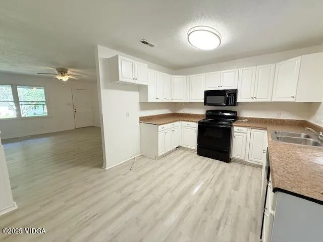 a kitchen with stainless steel appliances granite countertop a stove top oven a sink dishwasher and a refrigerator