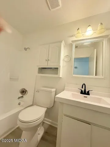 a bathroom with a sink a toilet and mirror