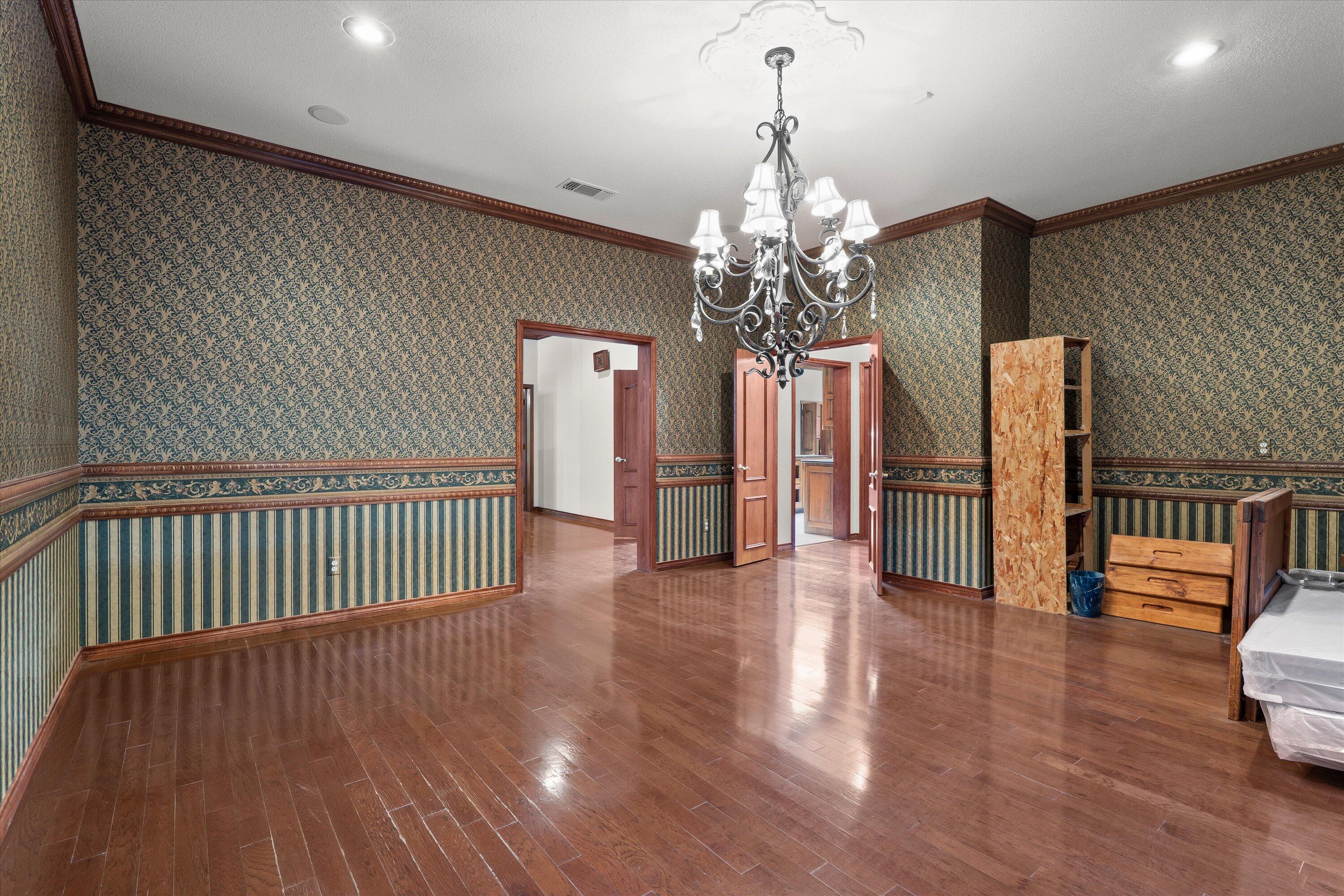 2404 York Avenue Lubbock, TX 79407 - Photo 21 of 88 a view of a livingroom with wooden floor and chandelier
