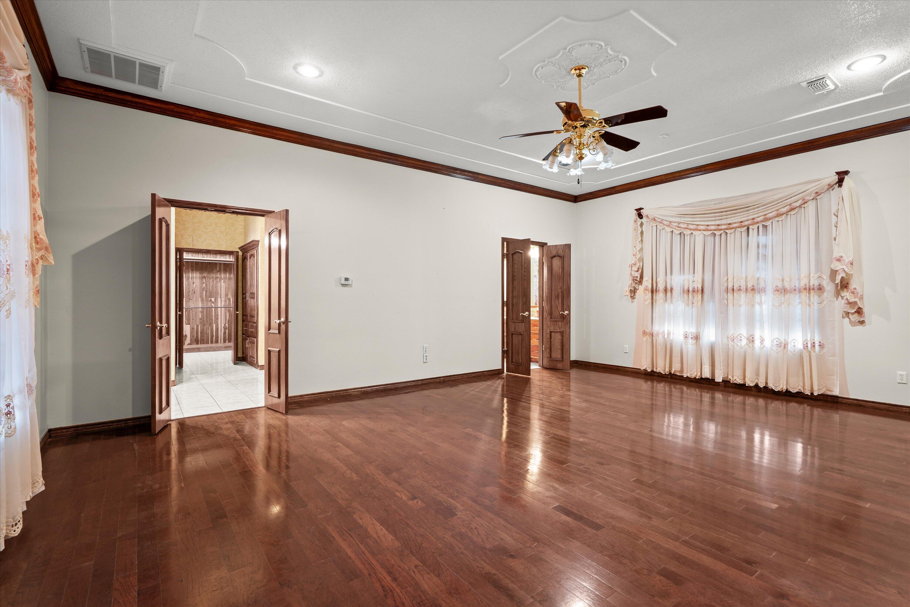2404 York Avenue Lubbock, TX 79407 - Photo 22 of 88 a view of an empty room with wooden floor and a ceiling fan