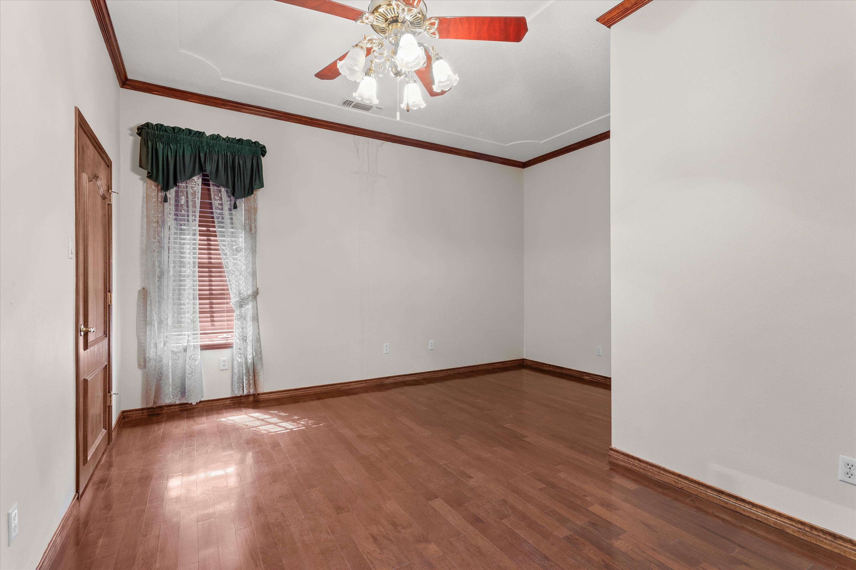 2404 York Avenue Lubbock, TX 79407 - Photo 53 of 88 an empty room with wooden floor chandelier fan and windows