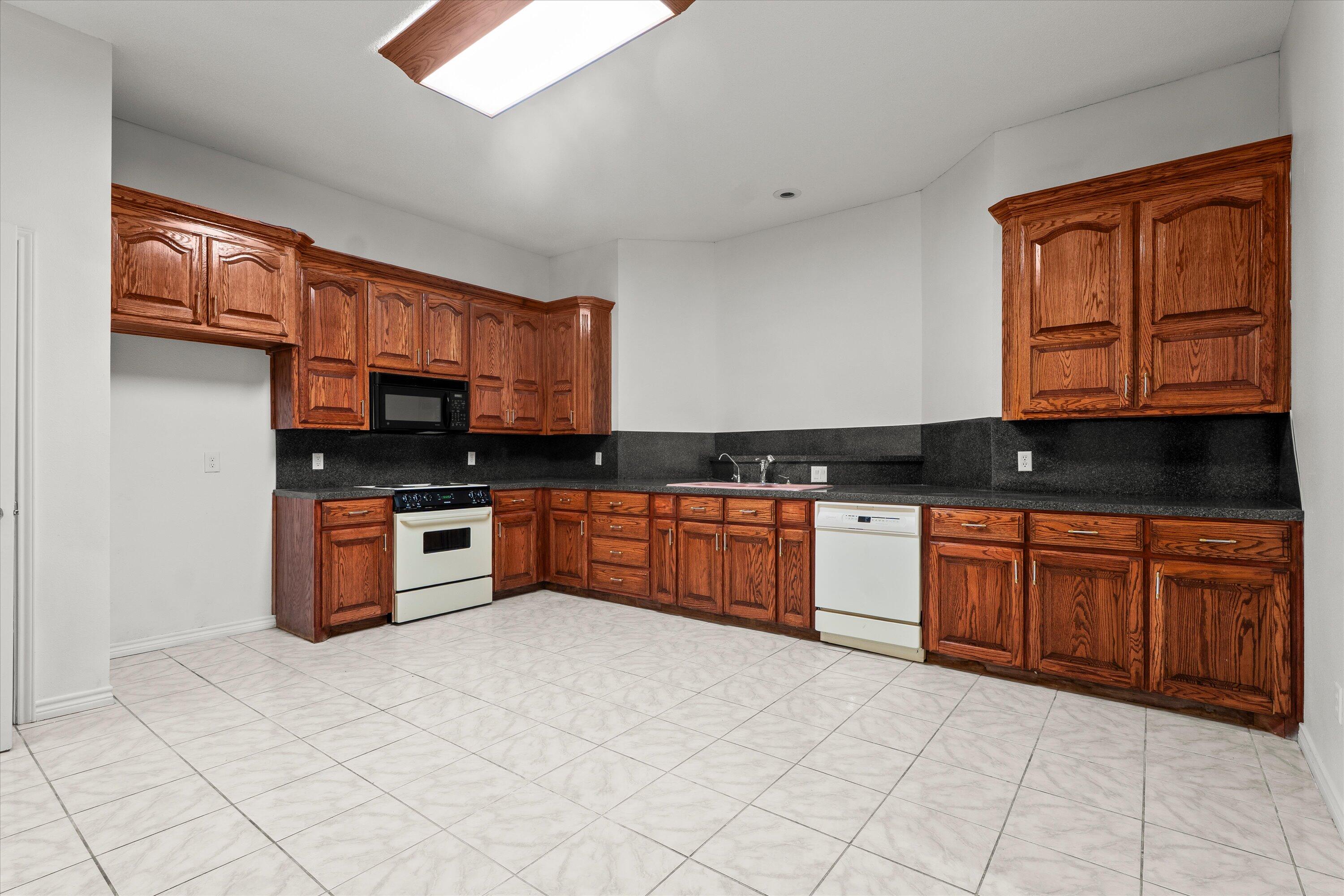 2404 York Avenue Lubbock, TX 79407 - Photo 70 of 88 a large kitchen with stainless steel appliances granite countertop a stove a sink and a microwave