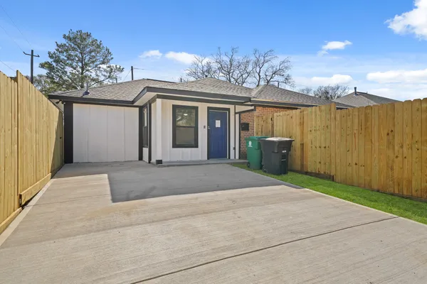 a view of a house with a yard and potted plants