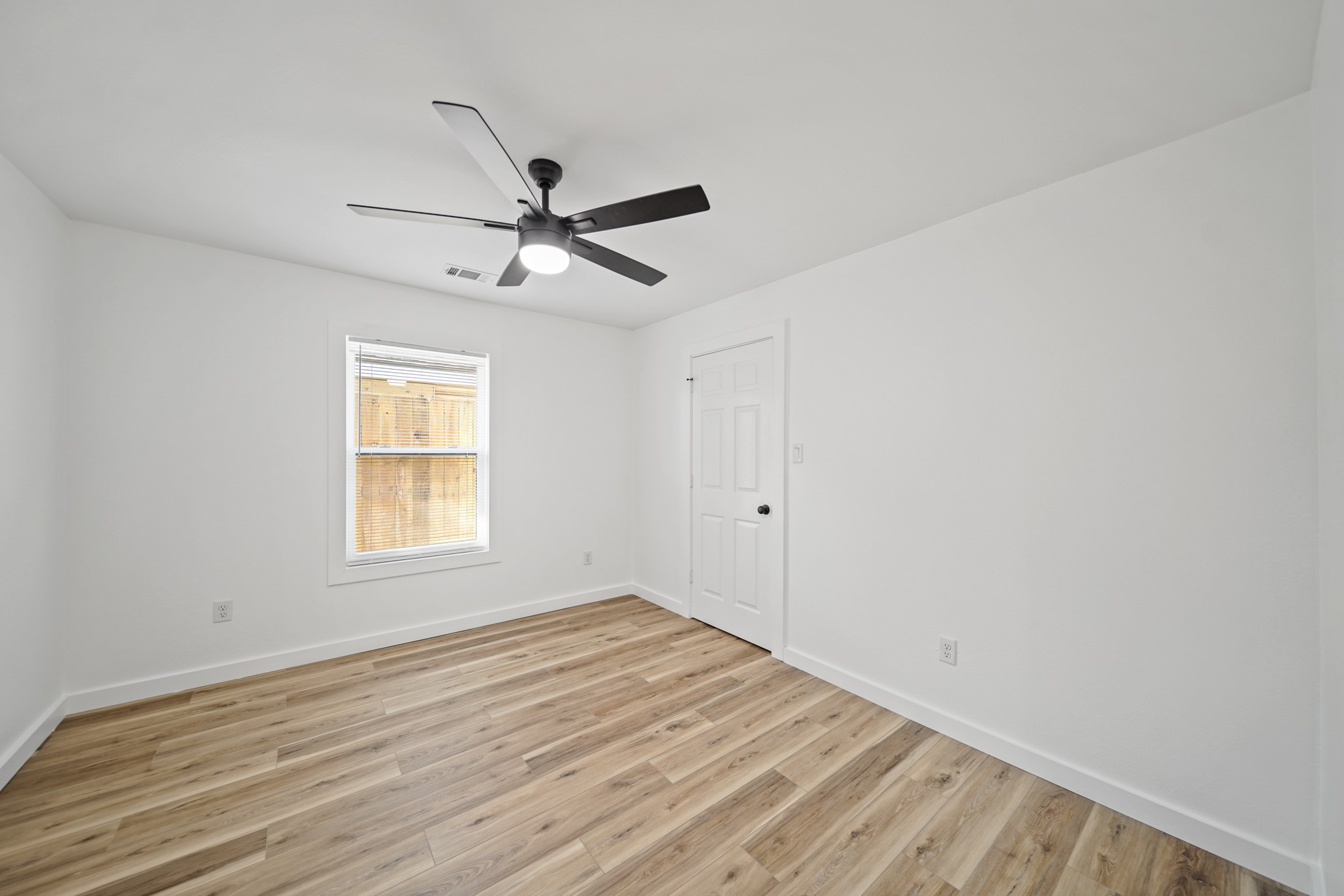 4154 Erby Street Houston, TX 77087 - Photo 12 of 36 a view of empty room with wooden floor and fan