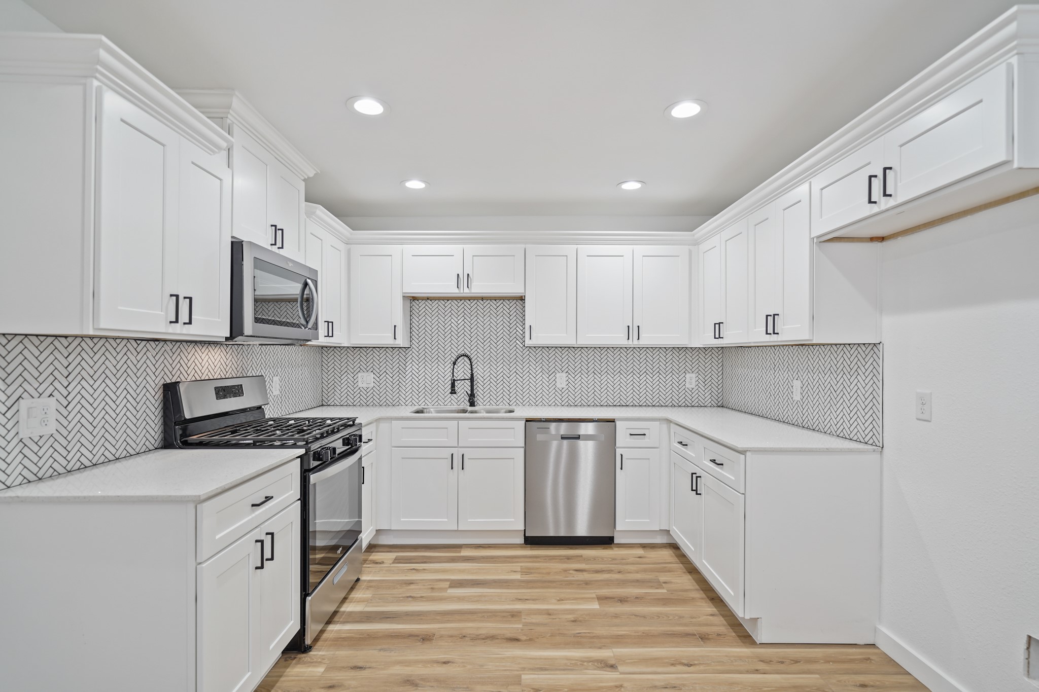 4154 Erby Street Houston, TX 77087 - Photo 9 of 36 a kitchen with stainless steel appliances granite countertop a stove a sink and white cabinets