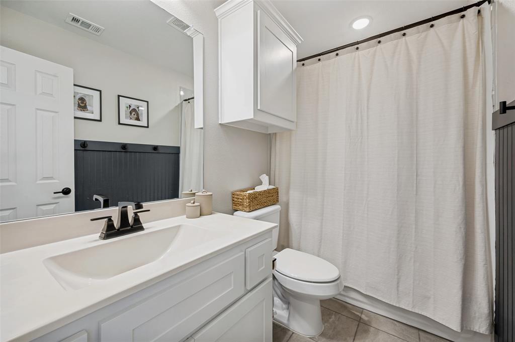 808 Violet Way Celina, TX 75009 - Photo 16 of 30 Upstairs bath with vanity, curtained shower, and bead board accent wall with towel hooks.