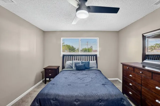 a bedroom with a bed and a ceiling fan