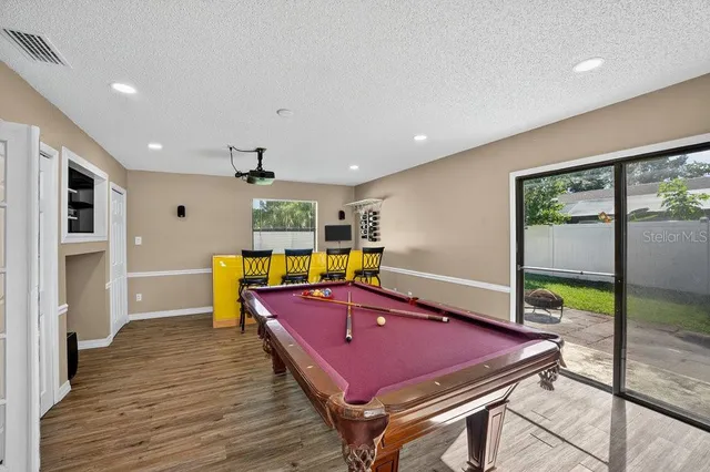 a room with wooden floor table and gym equipment