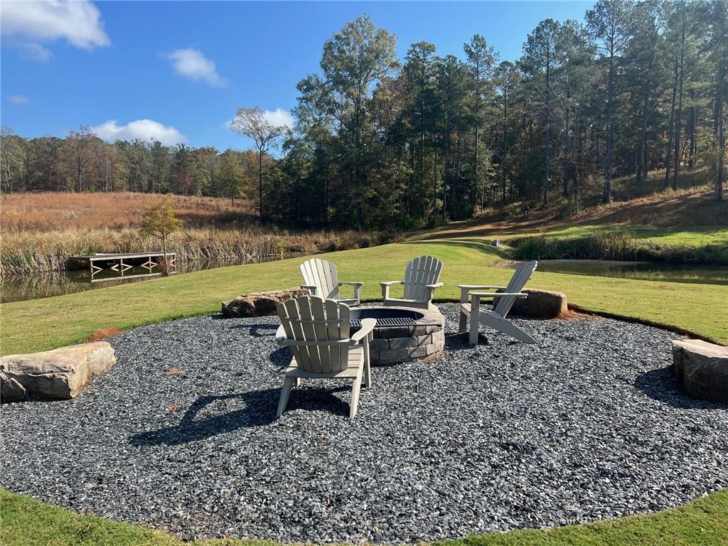 117 Overlook Drive Eatonton, GA 31024 - Photo 23 of 30 a view of a lake with lawn chairs and a fire pit