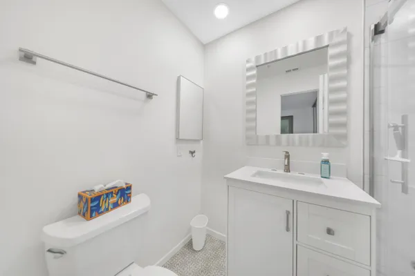 a bathroom with a sink mirror vanity and toilet