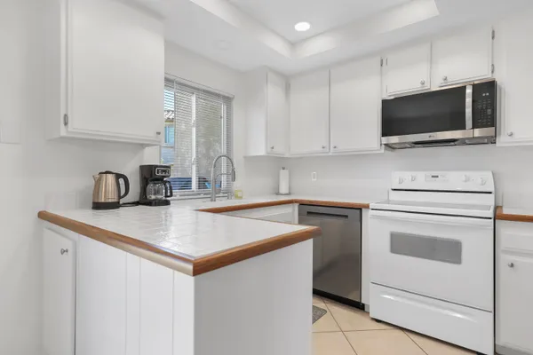 a kitchen with white cabinets stainless steel appliances and sink