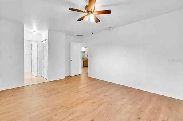 a view of an empty room and a ceiling fan