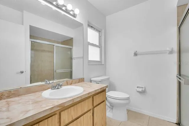 a bathroom with a granite countertop sink toilet a large mirror and shower