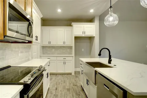 a kitchen with kitchen island granite countertop a sink stainless steel appliances and cabinets