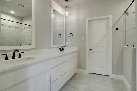 a bathroom with a double vanity sink a mirror and a shower