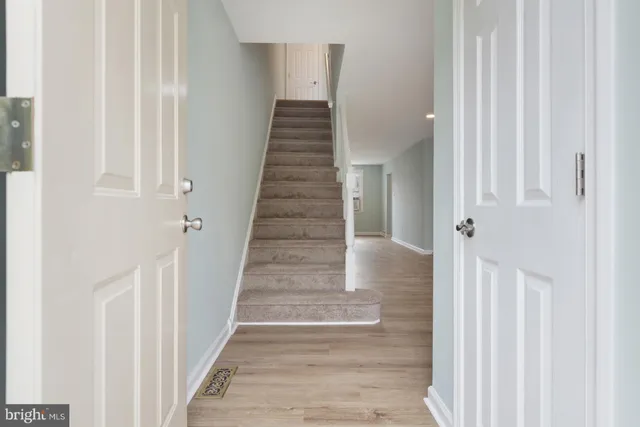 a view of a hallway with wooden floor and entryway