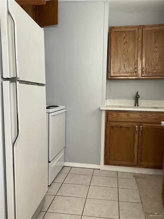 412 East 18th Street, Unit A Weslaco, TX 78596 - Photo 10 of 13 Kitchen featuring brown cabinetry, white appliances, and light tile patterned floors