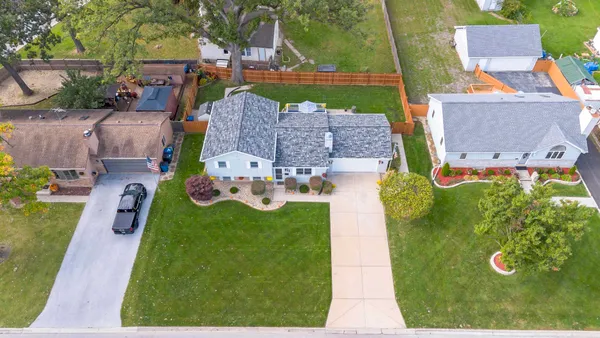 an aerial view of residential houses with outdoor space and parking